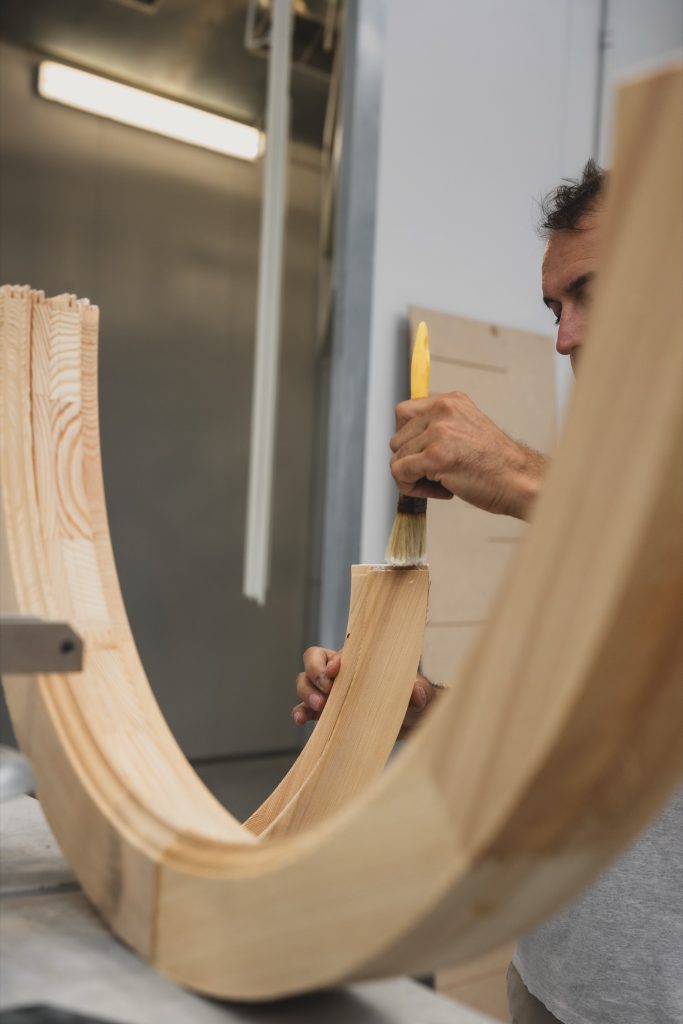 Mani di un artigiano Cafasso al lavoro su un serramento in legno