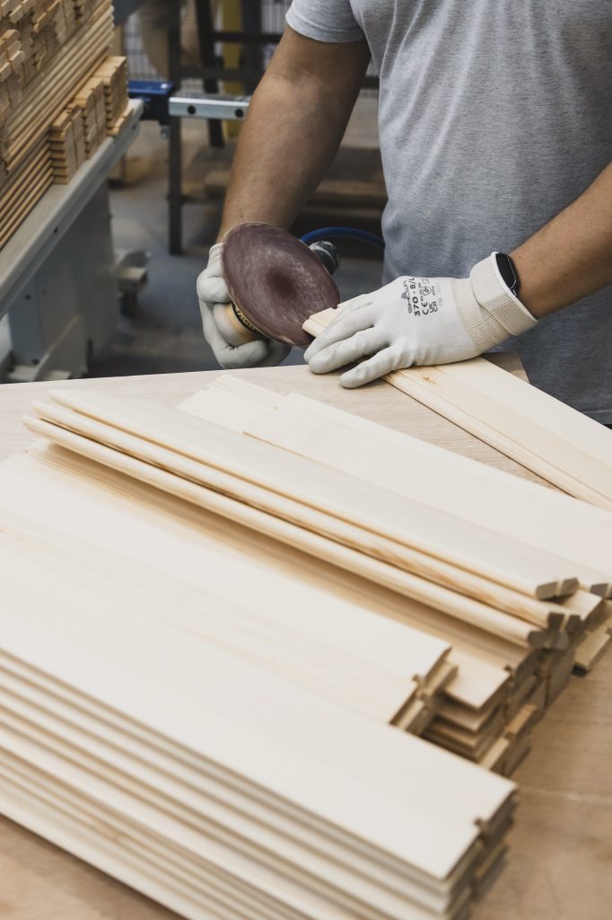 Mani di un artigiano Cafasso al lavoro su un serramento in legno