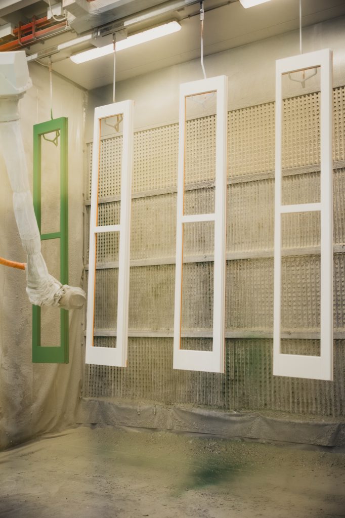 Fase di verniciatura di un serramento in legno nel laboratorio Cafasso