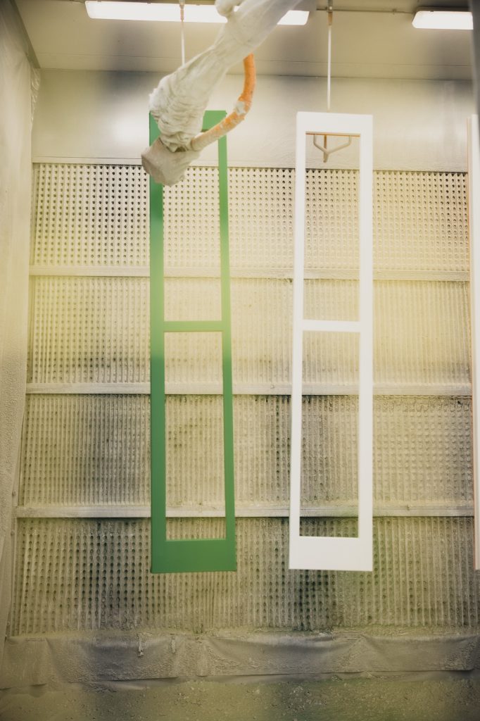 Fase di verniciatura di un serramento in legno nel laboratorio Cafasso