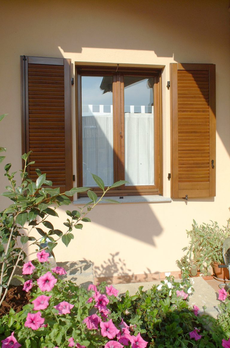 Finestra in legno in stile contemporaneo con persiane americane