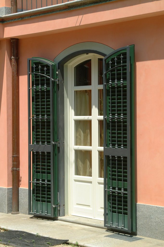 Portafinestra centinata in stile piemontese con persiane verdi