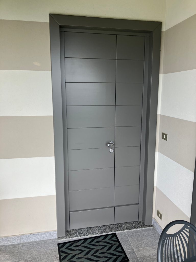 Portoncino d’ingresso grigio con fresature orizzontali e verticali