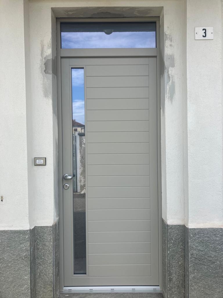 Portoncino d’ingresso grigio a doghe orizzontali, con vetro laterale e sopraluce