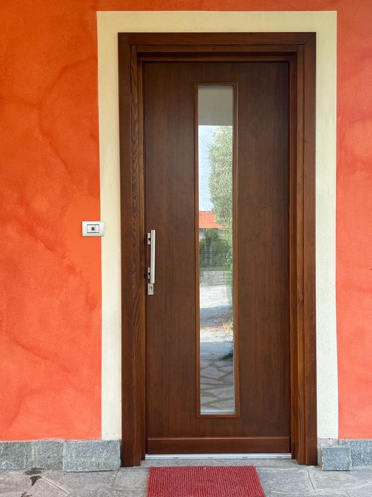 Portoncino in legno scuro con vetro verticale e maniglione